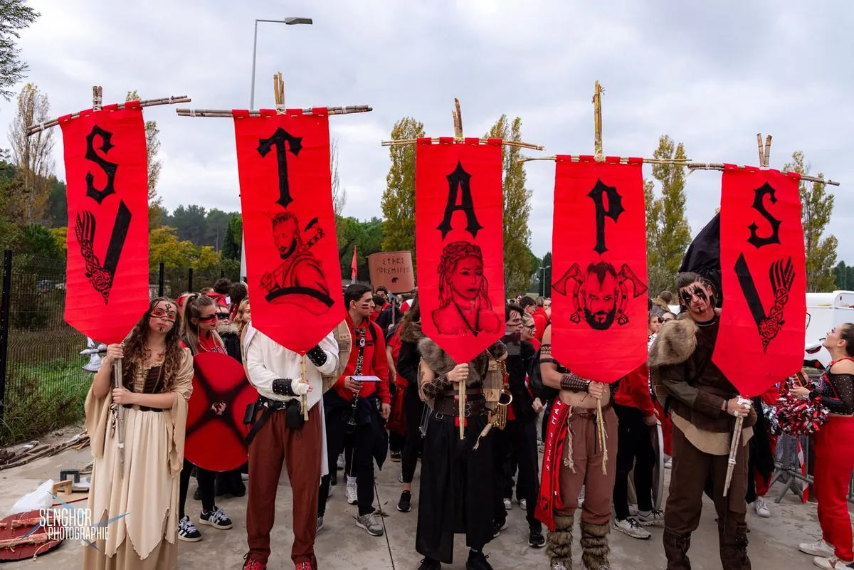 Cortège STAPS 2024 : cinq banderoles rouges peintes S T A P S, thème viking, costumes et maquillages